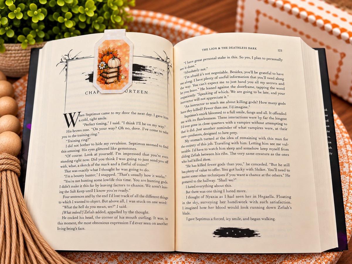 Back of Fall Reads Hit Different magnetic bookmark clipped over an open book