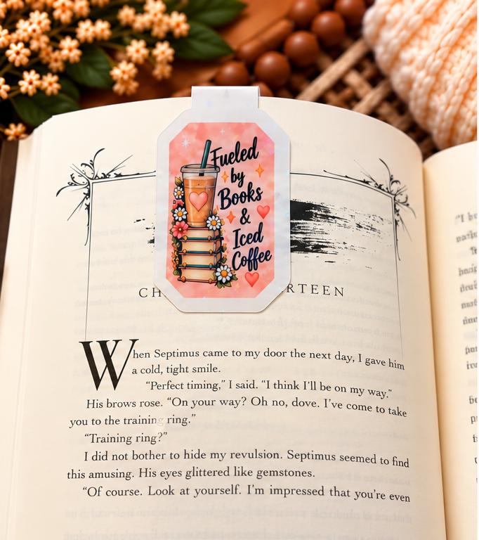 Fueled by Books and Iced Coffee magnetic bookmark front clipped over an open book