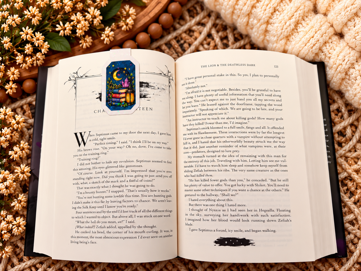 Late Night Reader magnetic bookmark front clipped over an open book